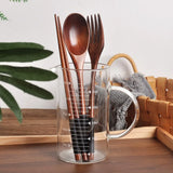 Nisu Home Cutlery Set displayed in a glass container with wooden spoons and forks for stylish dining