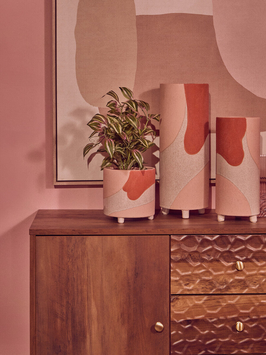 Stylish Orsina wall art featuring abstract shapes with decorative planters on a wooden dresser
