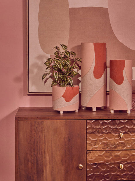 Stylish Orsina wall art featuring abstract shapes with decorative planters on a wooden dresser