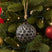 Honey Combe Bauble in black, featuring a textured design, hanging on a lush Christmas tree