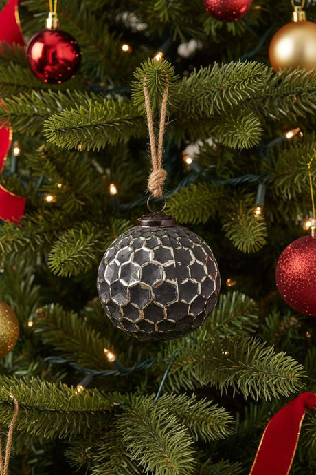 Honey Combe Bauble in black, featuring a textured design, hanging on a lush Christmas tree