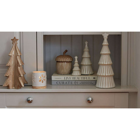 Snowy Layered Tree decorations displayed on a shelf with candles and books for Christmas room decor