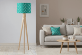 Stylish Shadow Bright lampshade in teal with white polka dots atop a wooden tripod lamp