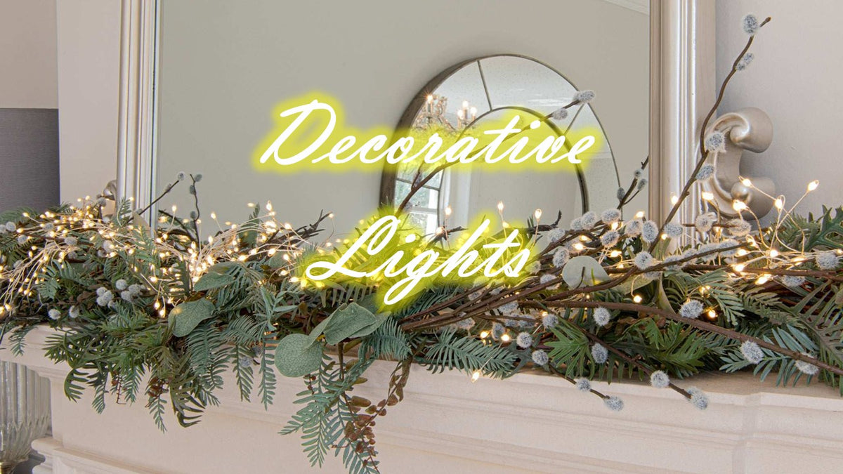 Elegant decorative setting with taper candles surrounded by greenery and fairy lights