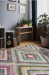 Colourful Diamond Rug in a stylish living room with plants and framed wall art