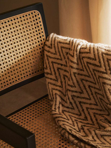 Orsina Dining Chair with Natural Cane and a Soft Blanket Draped Over the Backrest