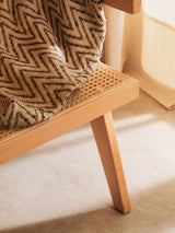 Orsina Dining Chair featuring a woven seat and wooden legs, perfect for elegant dining spaces