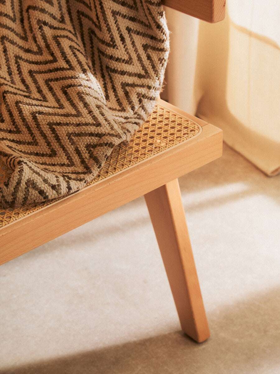 Orsina Dining Chair featuring a woven seat and wooden legs, perfect for elegant dining spaces