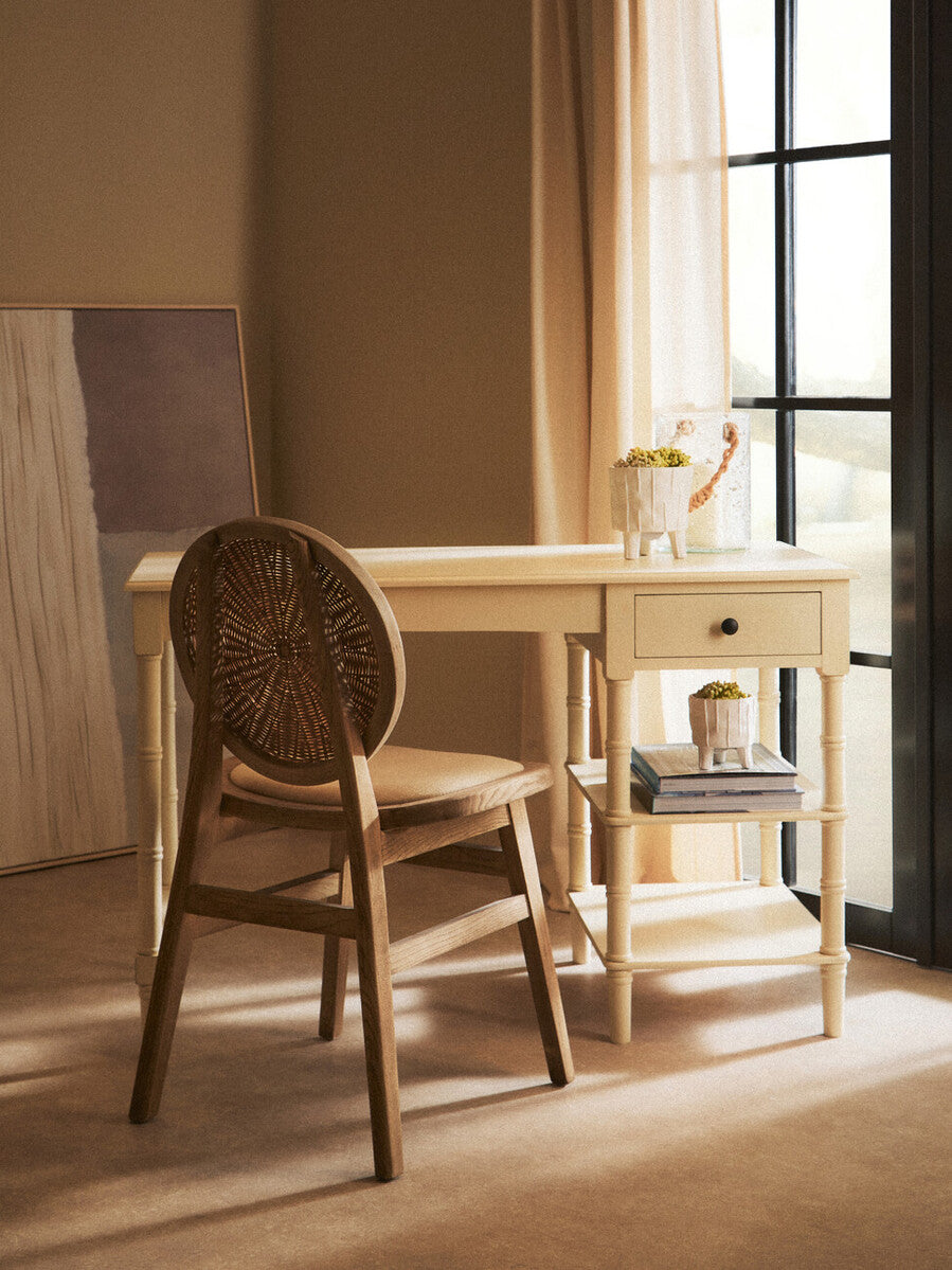 Orsina Dining Chair in natural wood with woven seat placed beside a stylish desk