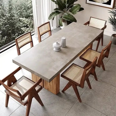 Nisu Home Dining Table with a modern concrete top and wooden base surrounded by stylish chairs