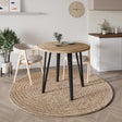 Decortie Dining Table with a round wooden top and black legs in a stylish modern setting