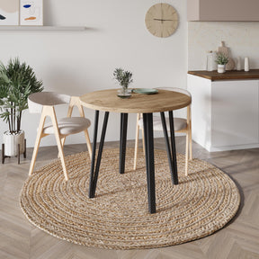 Decortie Dining Table with a round wooden top and black legs in a stylish modern setting
