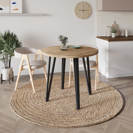 Decortie Dining Table with a round wooden top and black legs in a stylish modern setting
