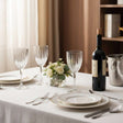 Elegant Orsina Wine Glasses on a dining table with a wine bottle and floral centerpiece
