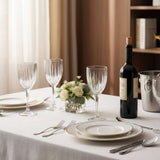 Elegant Orsina Wine Glasses on a dining table with a wine bottle and floral centerpiece