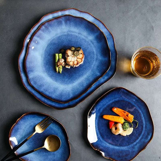 Elegant Nisu Home Dinner Plates in deep blue with wavy edges, featuring gourmet dishes