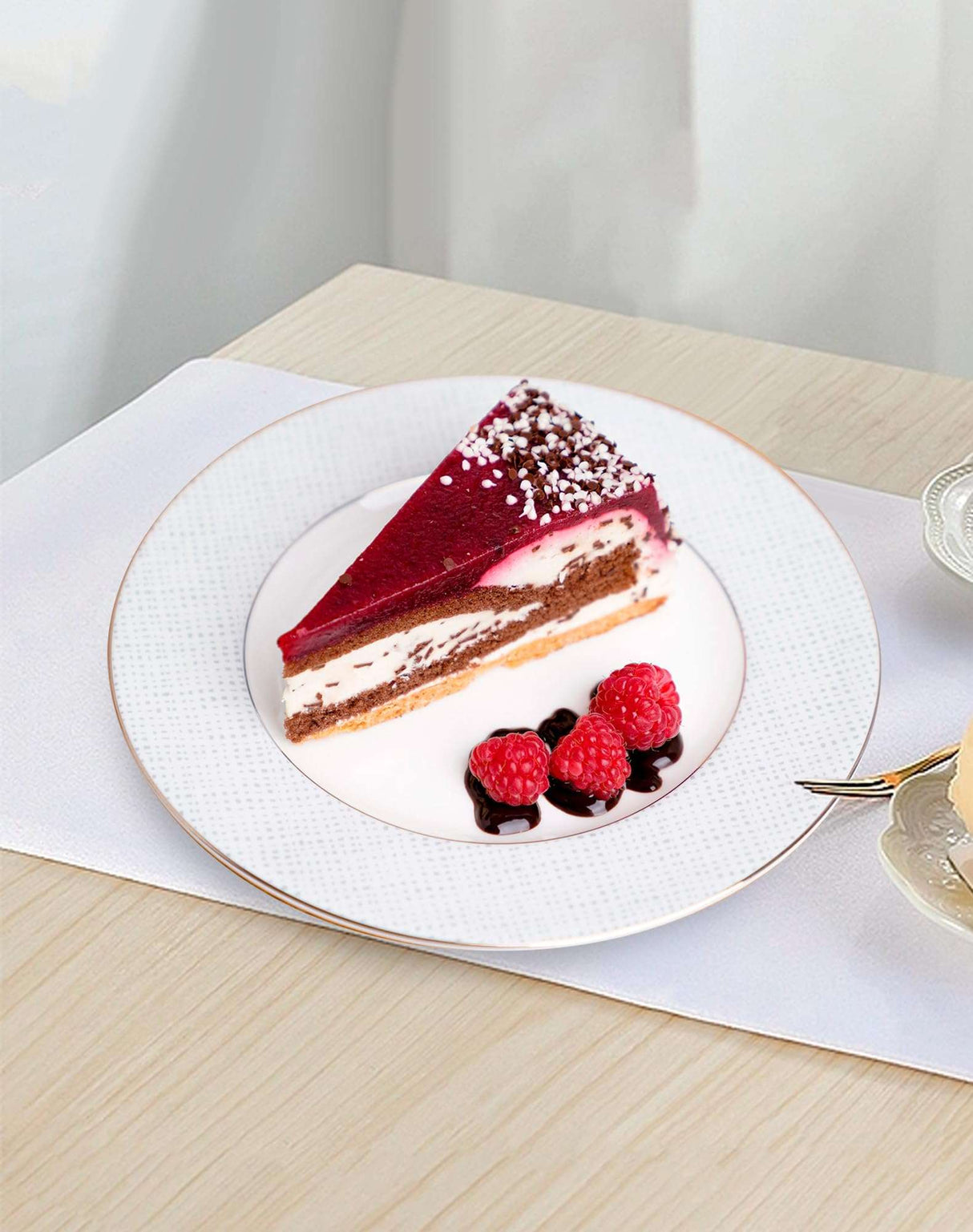 Elegant white dinner plates featuring a slice of cake with berries on a stylish table setting