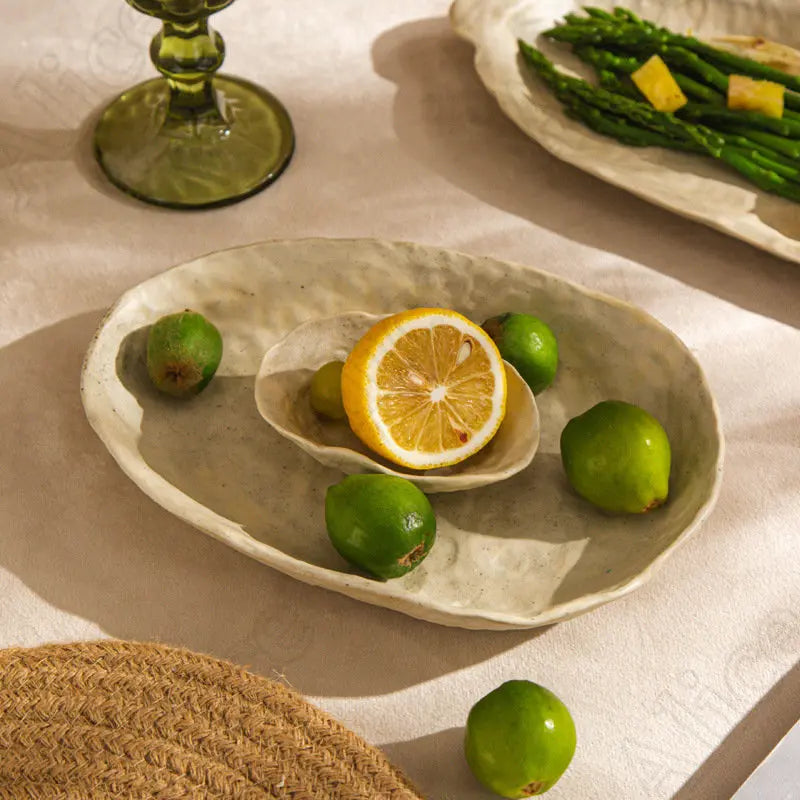 Doshim Tableware featuring an elegant ceramic serving dish with limes and lemon displayed on a table
