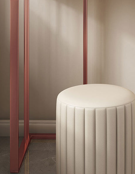 Elegant cream-coloured stool next to a chic dressing table with a rose gold frame