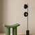 Modern green Dressing Table Stool next to a sleek black floor lamp in a minimalist setting
