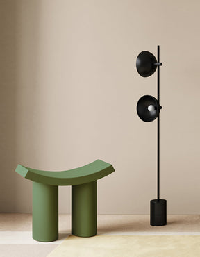 Modern green Dressing Table Stool next to a sleek black floor lamp in a minimalist setting