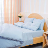 SHEET STORY Duvet Cover Set in soft blue hue on a stylish wooden bed with fluffy pillows