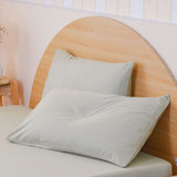 SHEET STORY Duvet Cover Set in soft pastel green with two matching pillows on a wooden bed frame