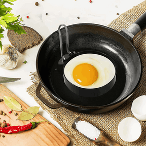 Orsina Egg Rings in a frying pan with a freshly cracked egg for perfect round omelettes