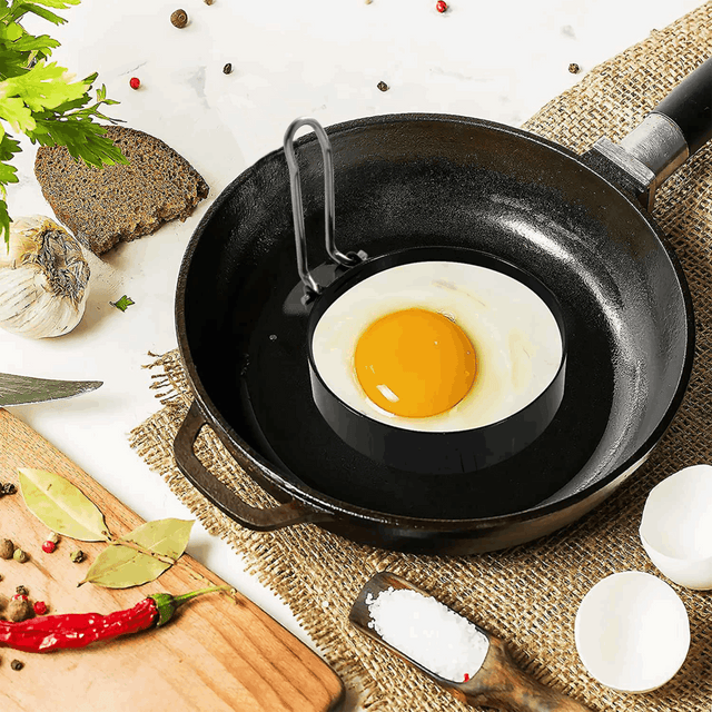 Orsina Egg Rings in a frying pan with a freshly cracked egg for perfect round omelettes