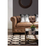 Orsina Embroidered Cushion featuring a stylish design on a leather Chesterfield sofa
