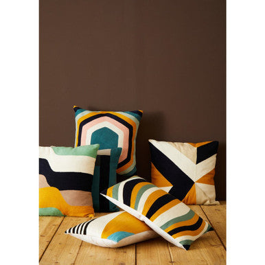 Assorted Orsina Embroidered Cushions in vibrant geometric patterns on a wooden floor