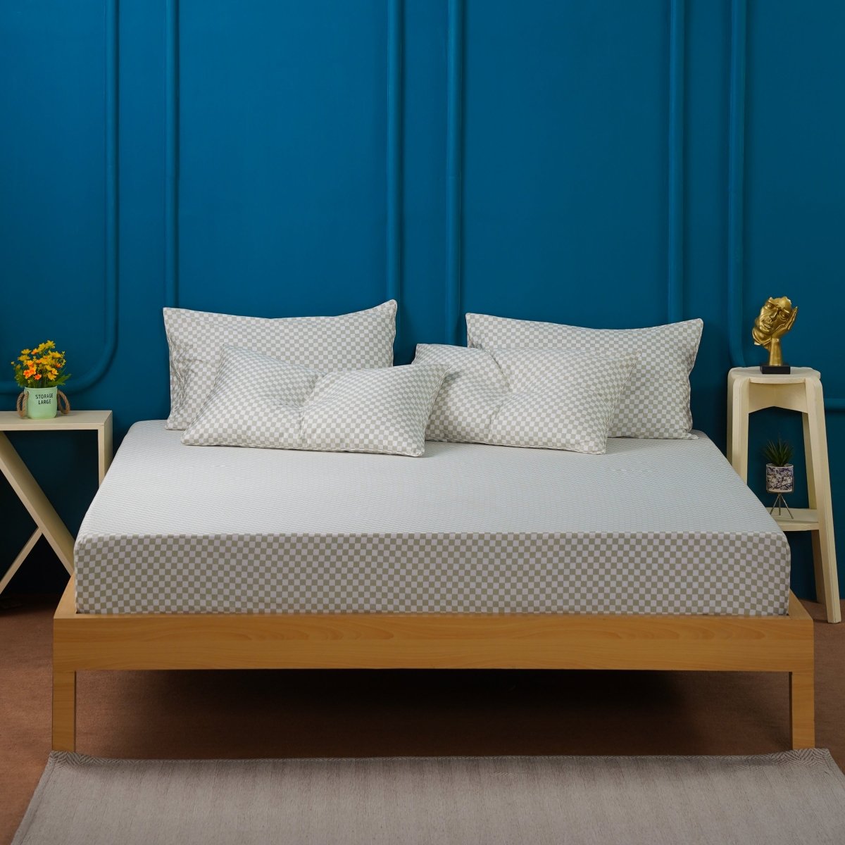 SHEET STORY Fitted Sheet on a wooden bed with decorative pillows against a blue wall