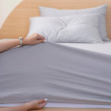 SHEET STORY Grey Fitted Sheet being stretched on a mattress for a perfect fit
