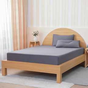 SHEET STORY Grey Fitted Sheet on a light wood bed with matching pillows for a stylish bedroom look