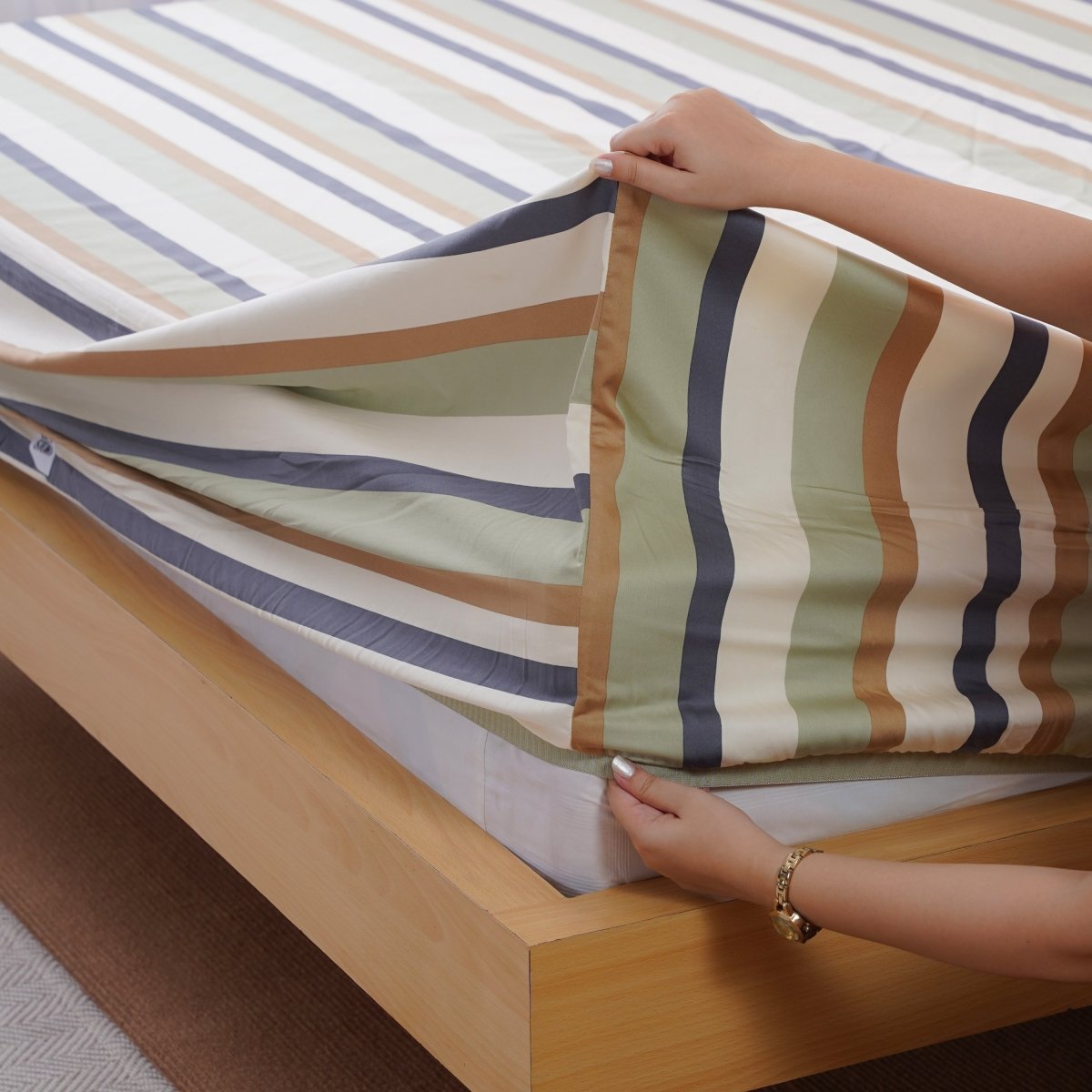 SHEET STORY Fitted Sheet with Multicolour Stripes Being Placed on a Bed for a Fresh Look