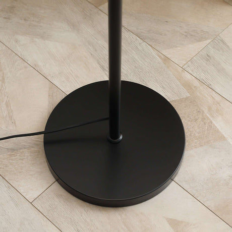 Stylish black base of the Wise Galleria Floor Lamp on a wooden floor, featuring a minimalist design