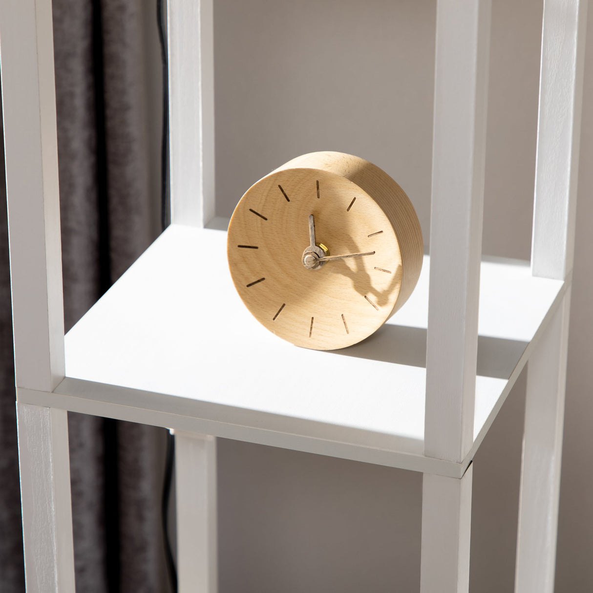 Stylish white bookcase with a wooden clock, perfect for displaying a floor lamp and home decor