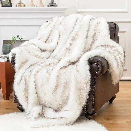 Luxurious cream faux fur throw draped over a brown leather armchair for a cosy home decor touch