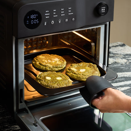 Fridja Digital Air Fryer with Cookies Baking Tray and User Hand in Oven for Perfect Cooking