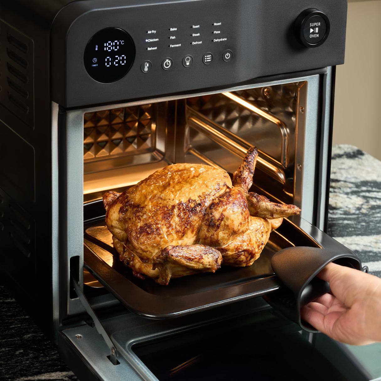 Fridja Digital Air Fryer with Roast Chicken Inside and User Taking Tray Out