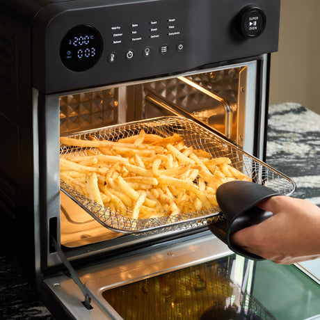 Fridja Digital Air Fryer Oven with frying basket filled with golden fries