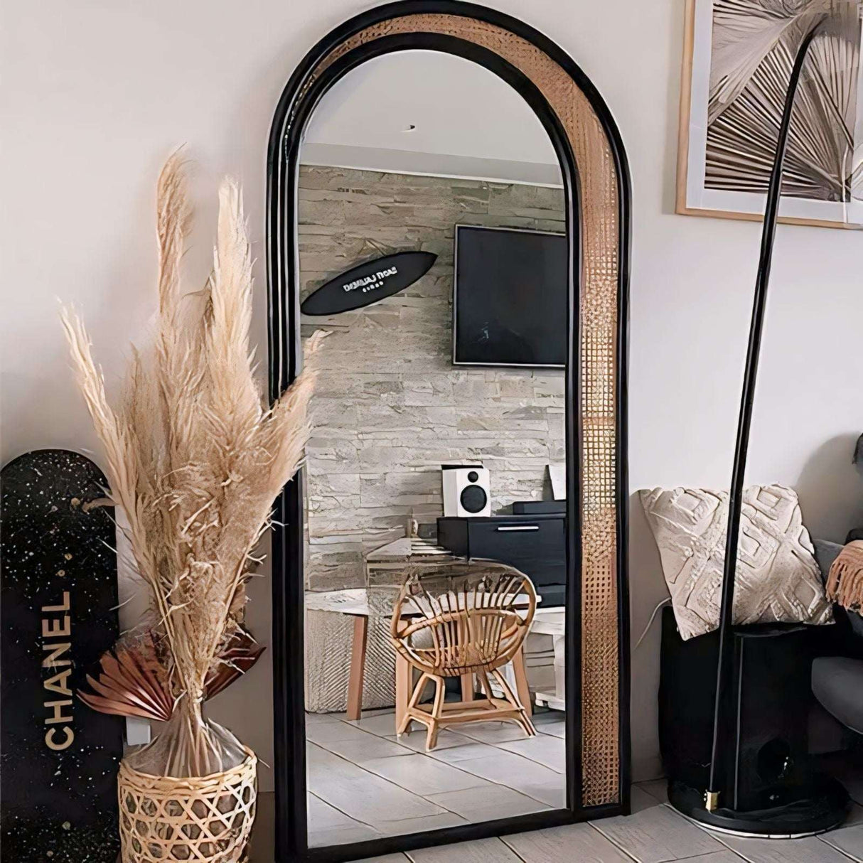 Elegant arched Nisu Home mirror with a black frame and natural rattan accents in a stylish interior