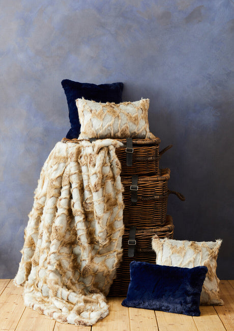 Orsina Fur Cushion in Cream and Navy against a textured backdrop for stylish home decor