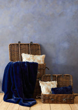 Orsina Fur Cushion in a stylish setting with woven baskets and a navy throw blanket