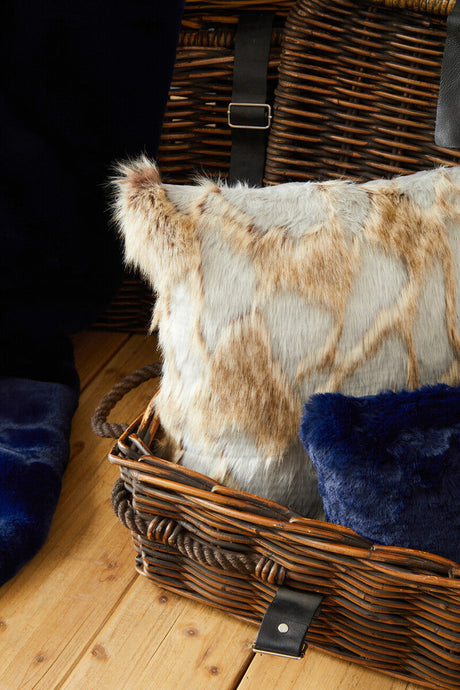 Orsina Fur Cushion in a textured design placed inside a wooden basket