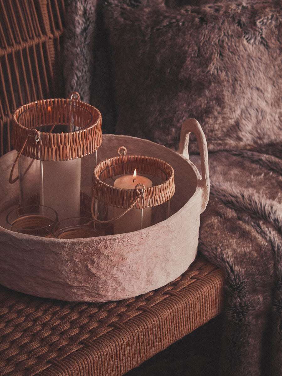 Orsina Fur Cushion in Soft Brown Placed on a Stylish Chair Next to Candle Holders