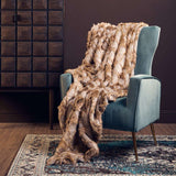 Orsina Fur Throw draped over a stylish teal armchair in a cozy living room setting