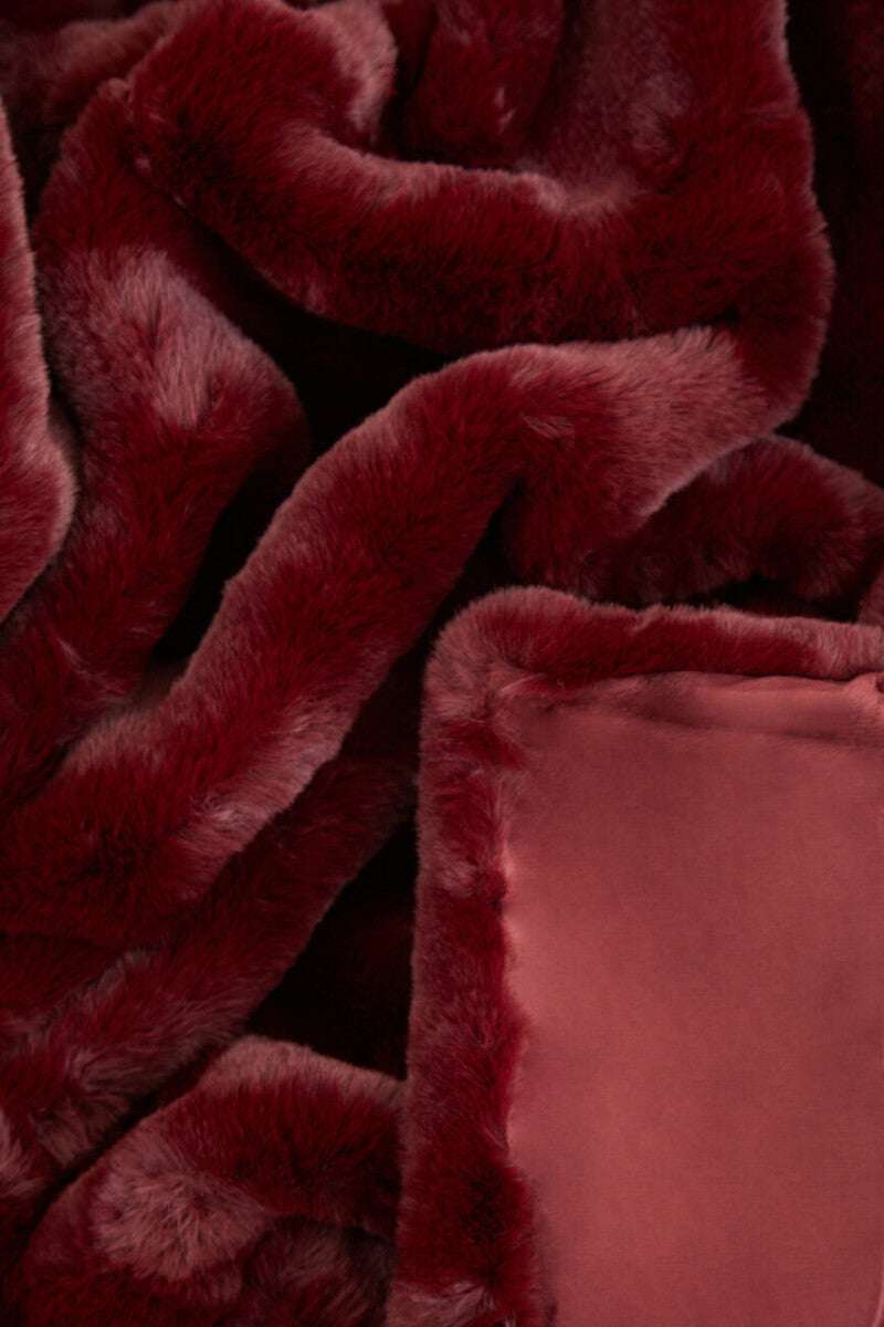 Rich burgundy Orsina Fur Throw made from soft faux fur for cozy warmth and style