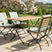 Stylish MINT Outdoor Garden Dining Set with four folding chairs and a wooden table in a scenic garden
