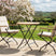 MINT Outdoor Garden Dining Set featuring a round table and two cushioned chairs in a scenic garden